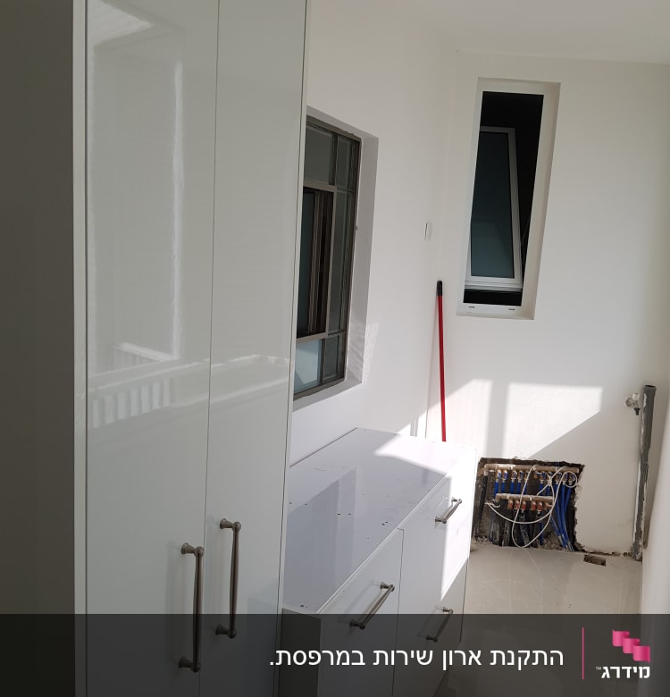 ארון לבן עם ידיות מתכת בחדר עבודה